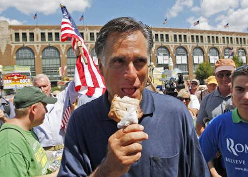 Mitt Romney eats a pork chop on a stick, using a napkin to protect his soft hands.